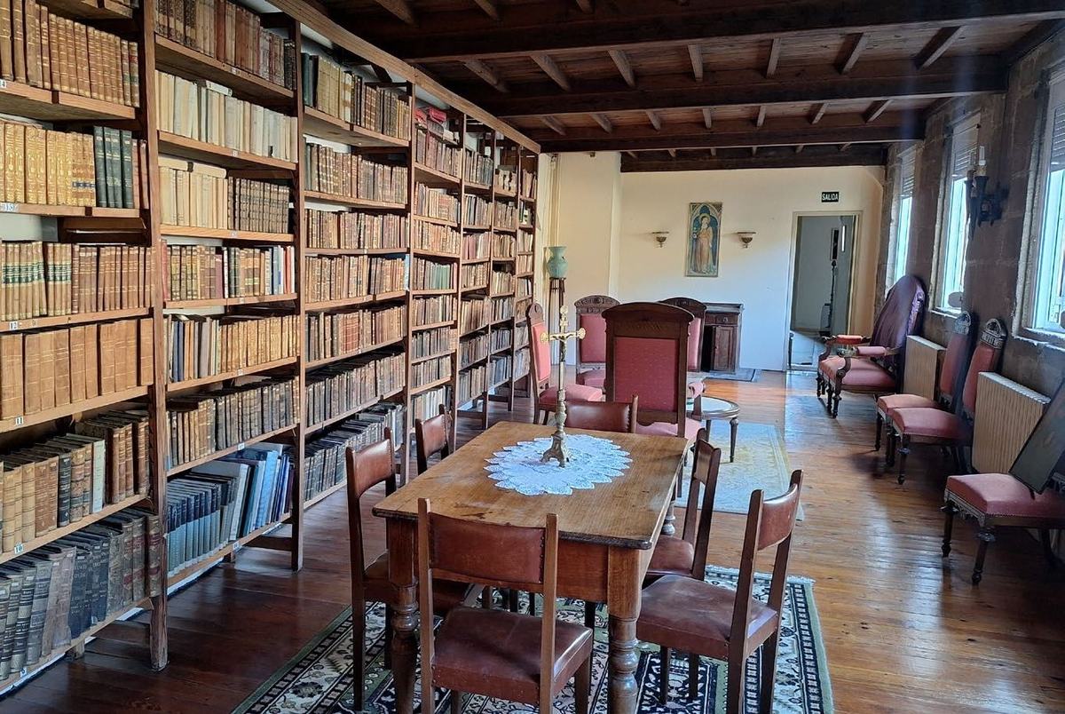 Biblioteca del convento con estanterías de madera y mesa larga